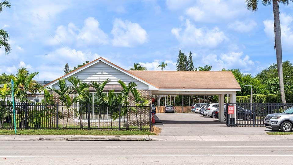 MCDS campus building exterior with palm trees