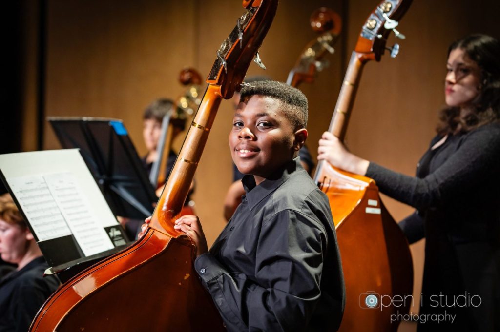 MCDS orchestra students performing on stage