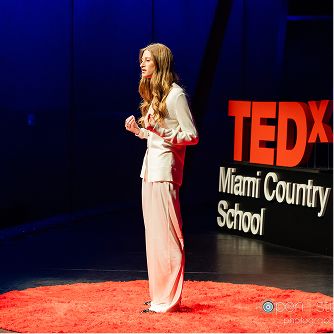 Student speaking on stage at a TEDx Miami Country Day School event