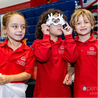 Young students posing with puppets during a school activity