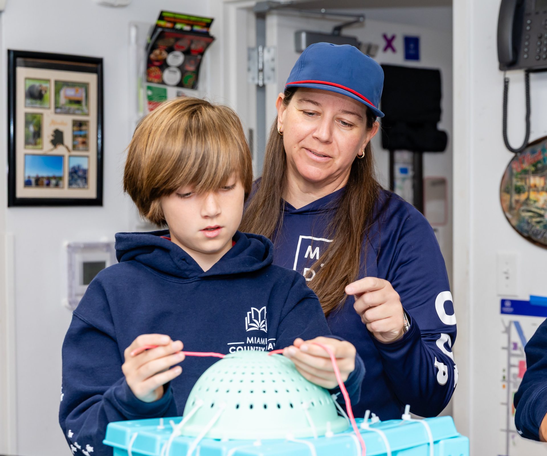 Student and teacher assembling a lamp shade in an art room