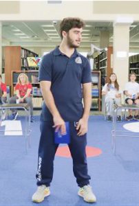 Upper School student standing indoors in an MCDS polo shirt