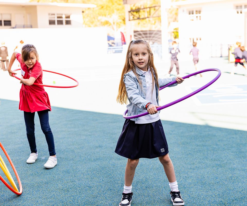 MCDS Lower School students playing outside with hula hoops