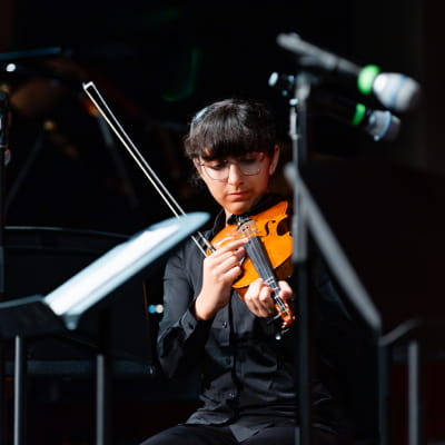 student playing violin at classical concert