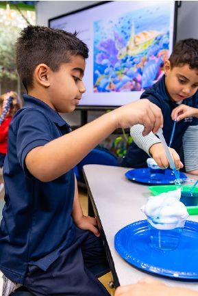 Young students doing a hands-on science experiment at their desks