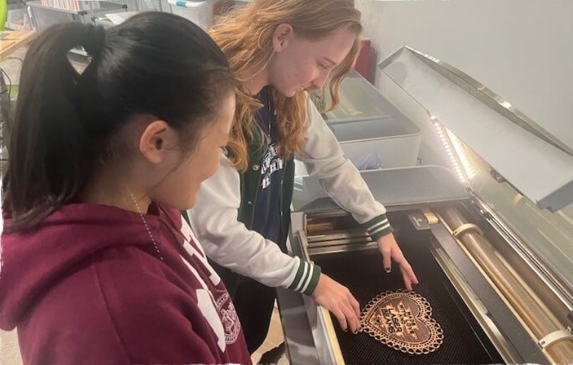 MCDS student using a laser cutter in the Garner Center for Innovation