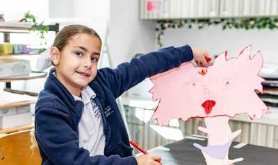 MCDS Lower School student displaying an art project