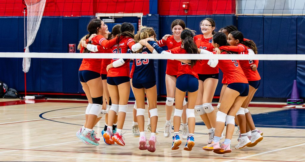 MCDS volleyball team celebrating together on the court