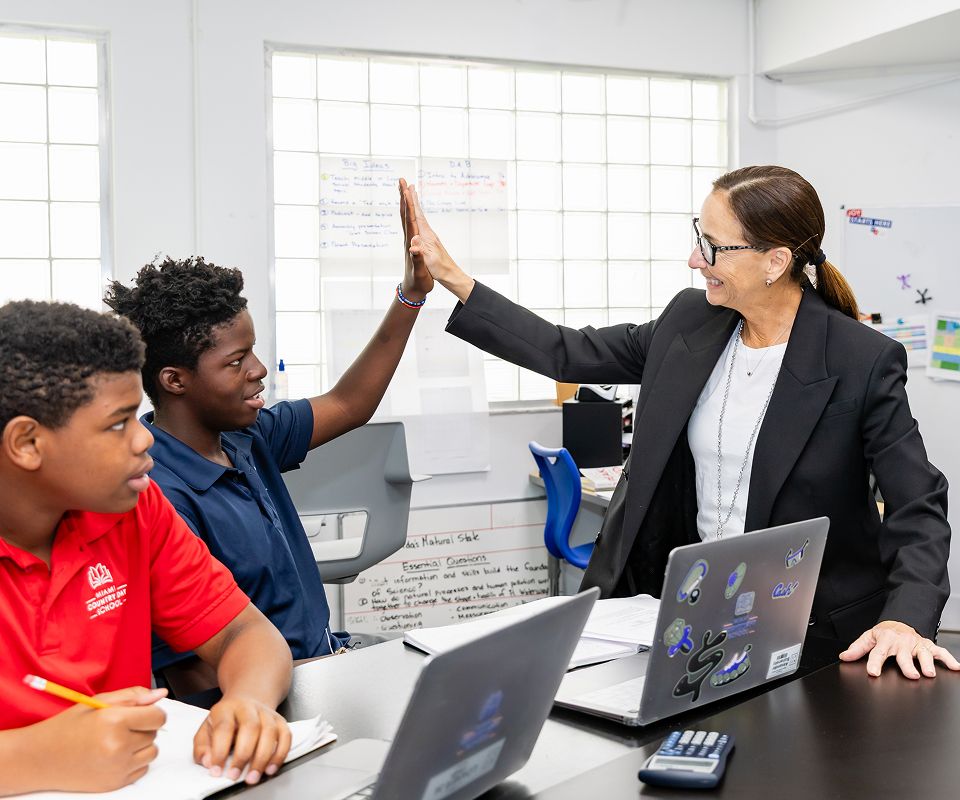 MCDS faculty member high-fiving a student in the classroom