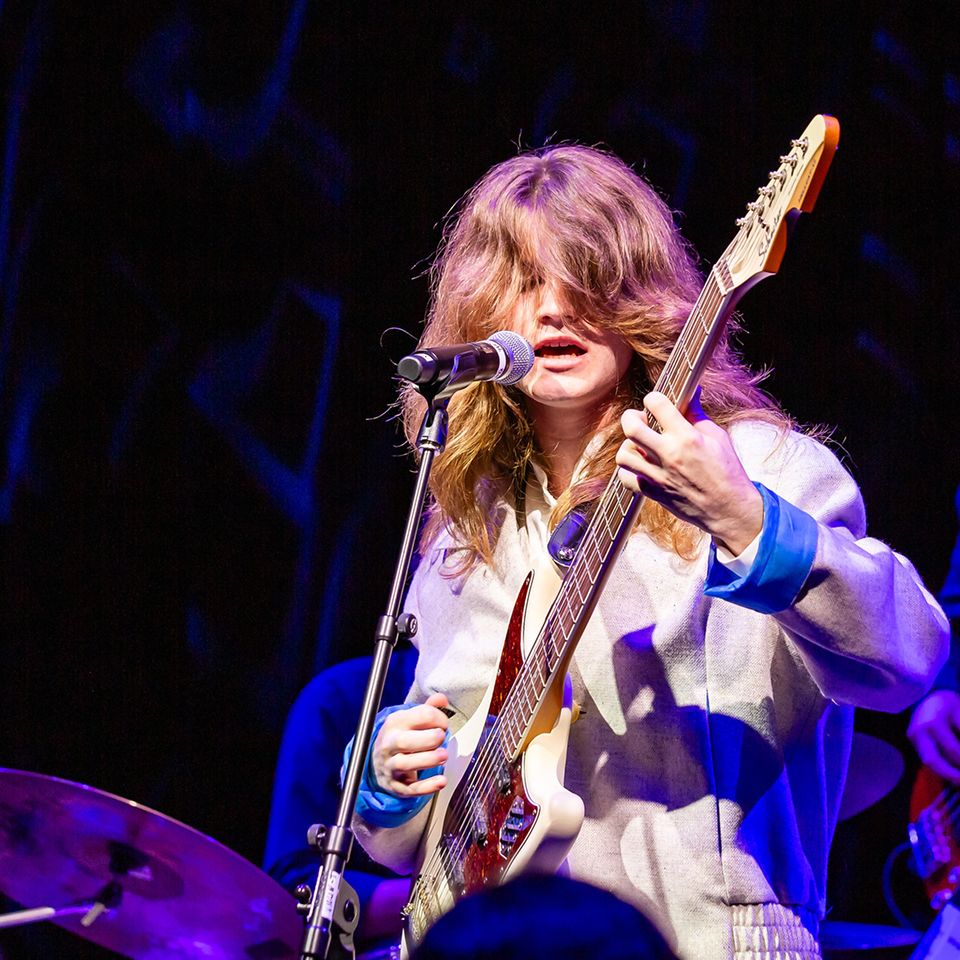 MCDS student playing guitar on stage during a Music performance