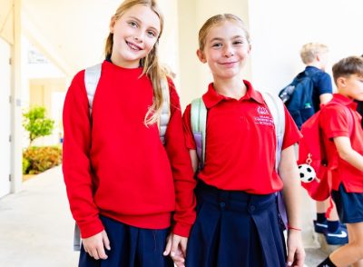 Two MCDS students in school uniforms with backpacks after the school day