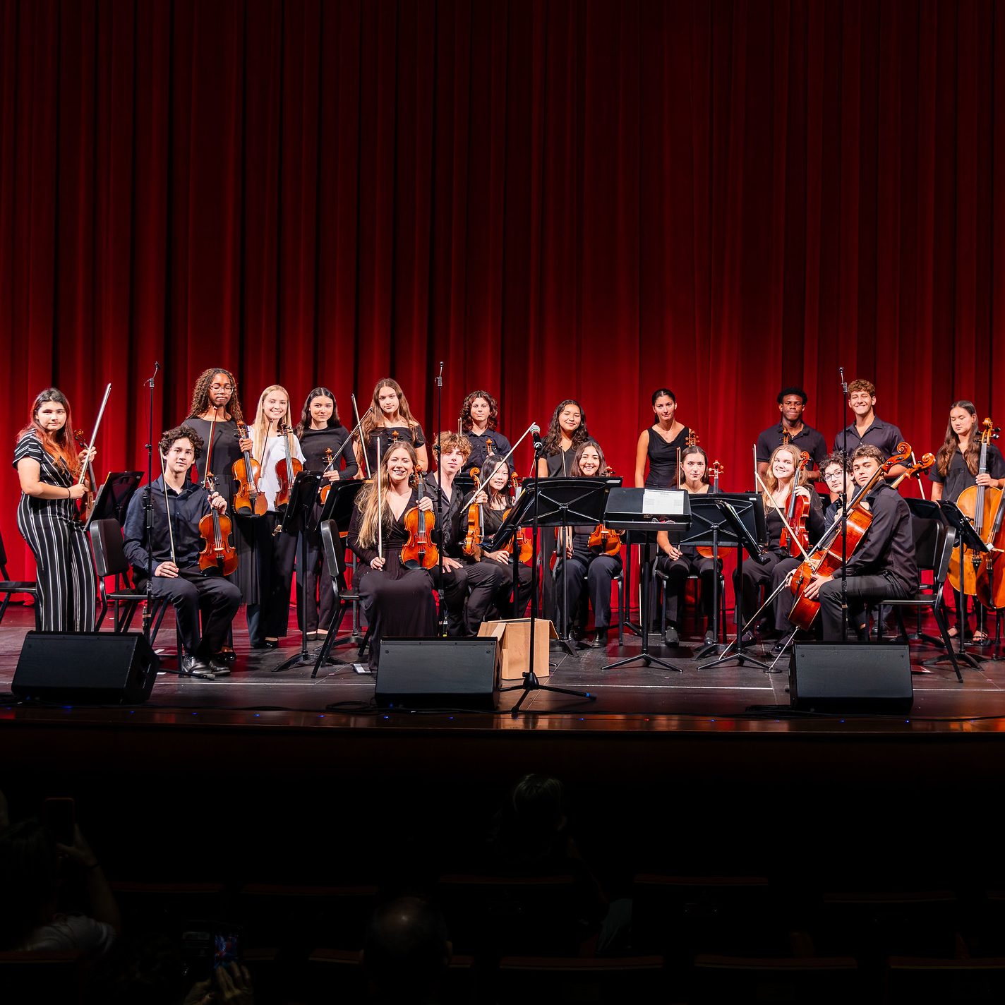 MCDS orchestra performing on a dark stage