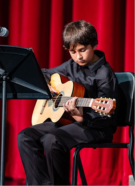 MCDS Arts student playing guitar on stage