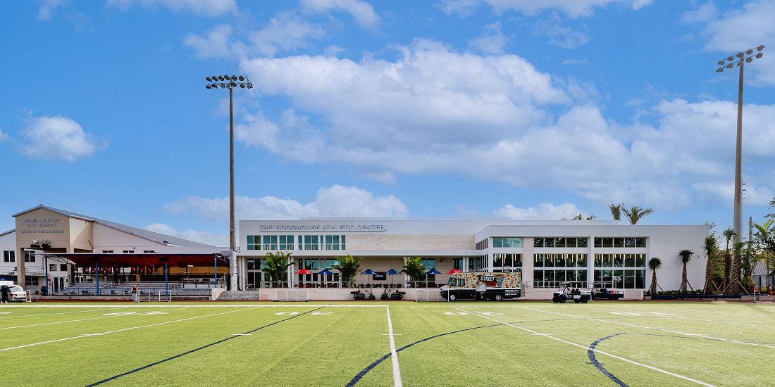 Empty MCDS athletic field with the field house behind it