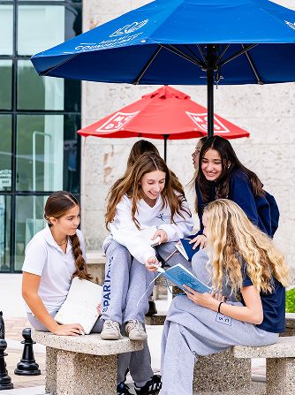 Group of MCDS students sitting together at an outdoor school area
