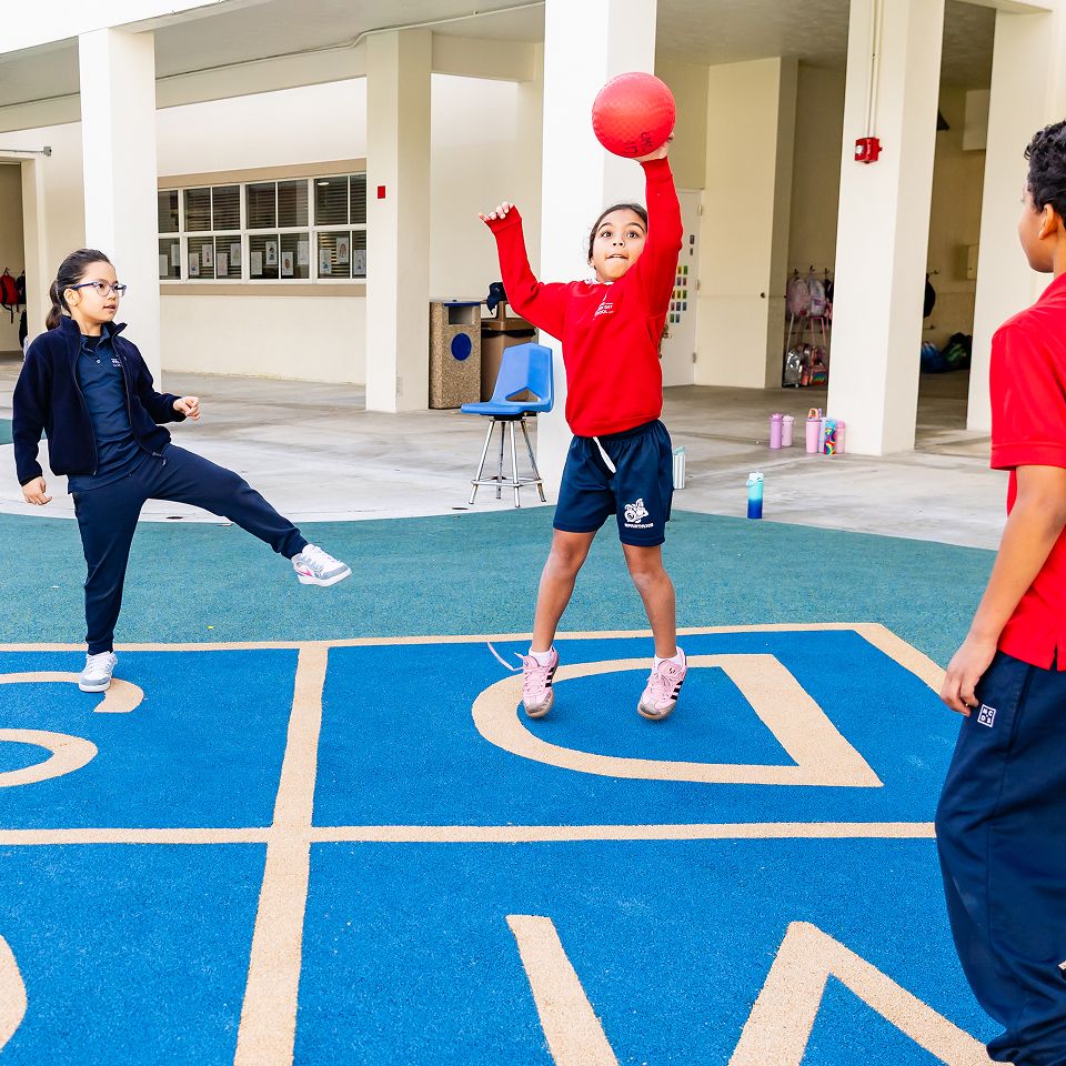 MCDS students playing basketball on an outdoor school court