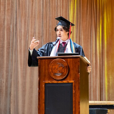 Graduate speaking at the podium during the Commencement ceremony