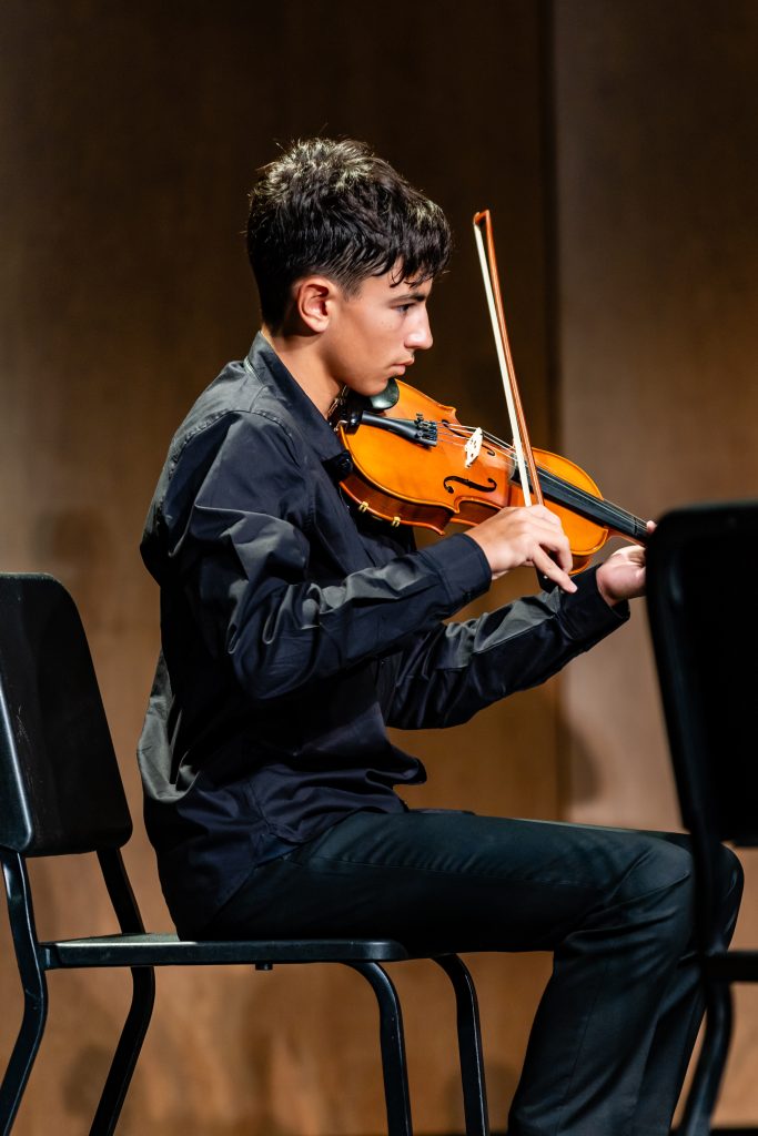 MCDS student performing violin at a classical concert