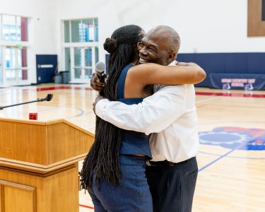 MCDS Spartan Athletics Hall of Fame event, honoree embracing a guest on the court