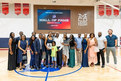 MCDS Spartan Athletics Hall of Fame group photo under the Hall of Fame banner