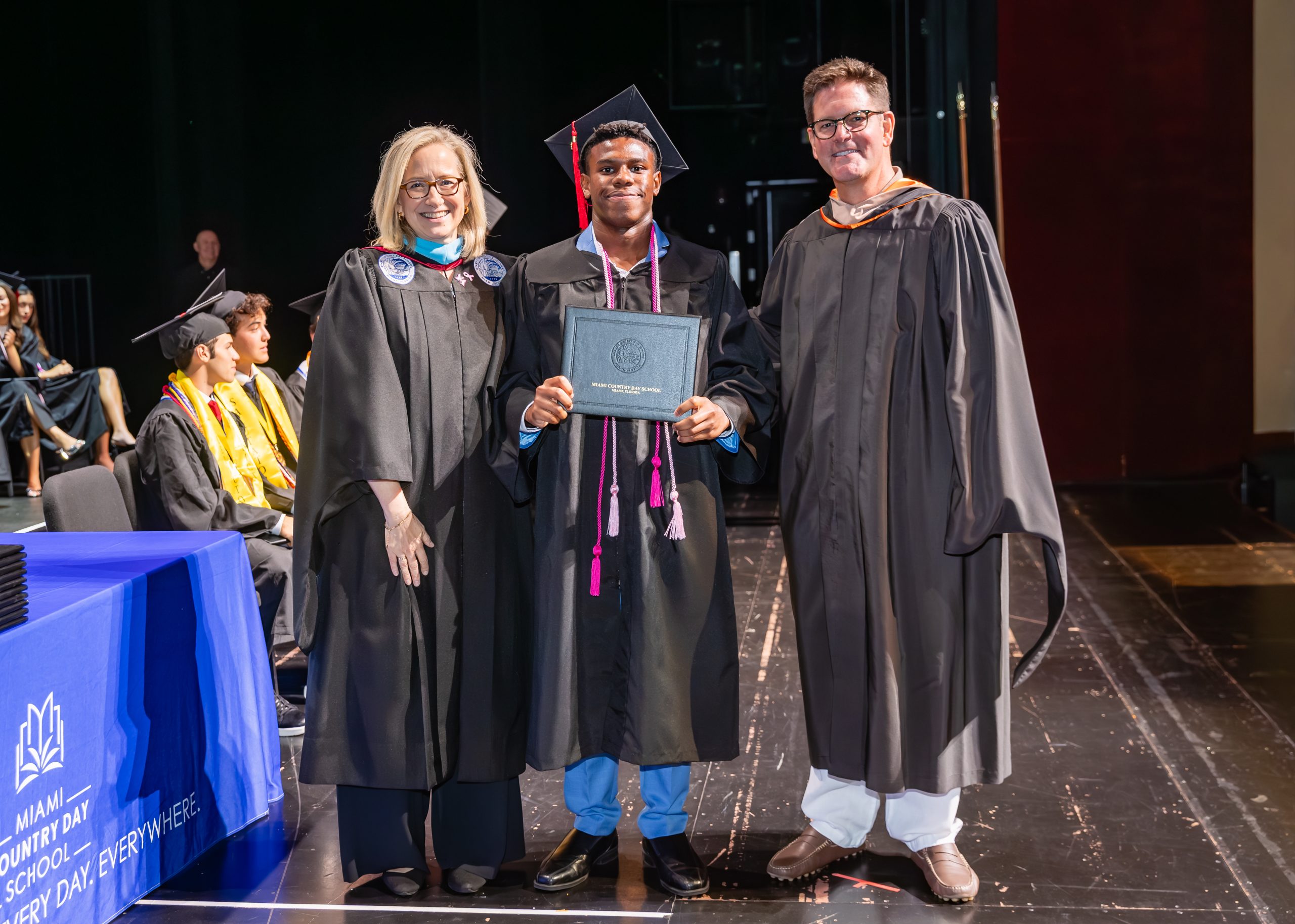 MCDS graduates embracing at the Commencement ceremony, shown on the Online School page