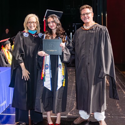 Graduate posing with family members after the Commencement ceremony
