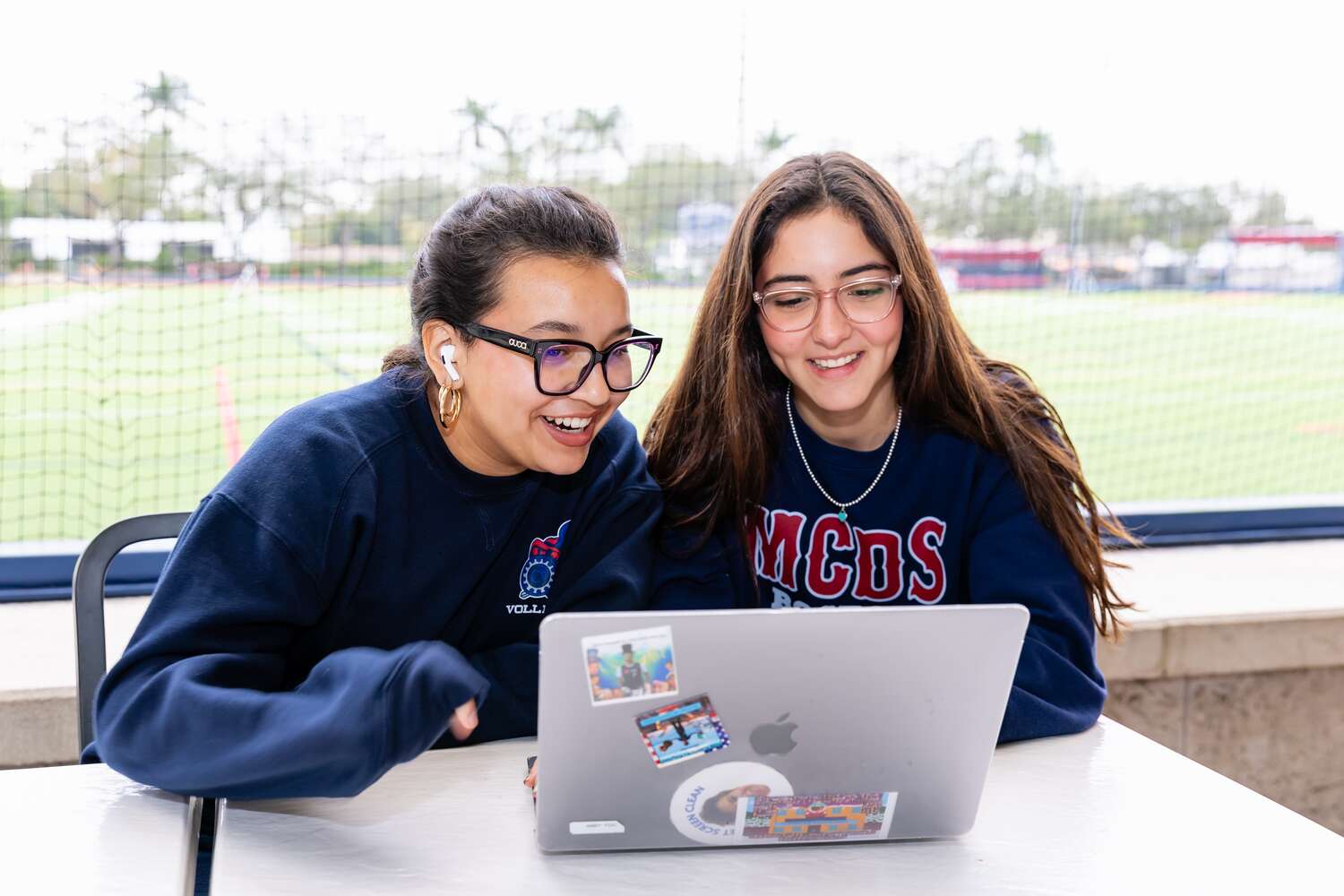 MCDS Upper School students working together on a laptop outdoors