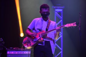 MCDS Upper School student playing guitar on stage, from a news post about Andrew Weaver '21