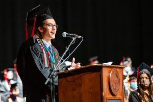 MCDS graduate speaking at the podium during a commencement ceremony