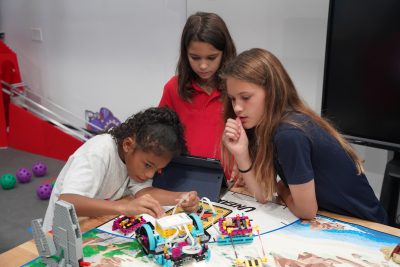 MCDS students and family working on a project together, shown on the EI² Honor Society page