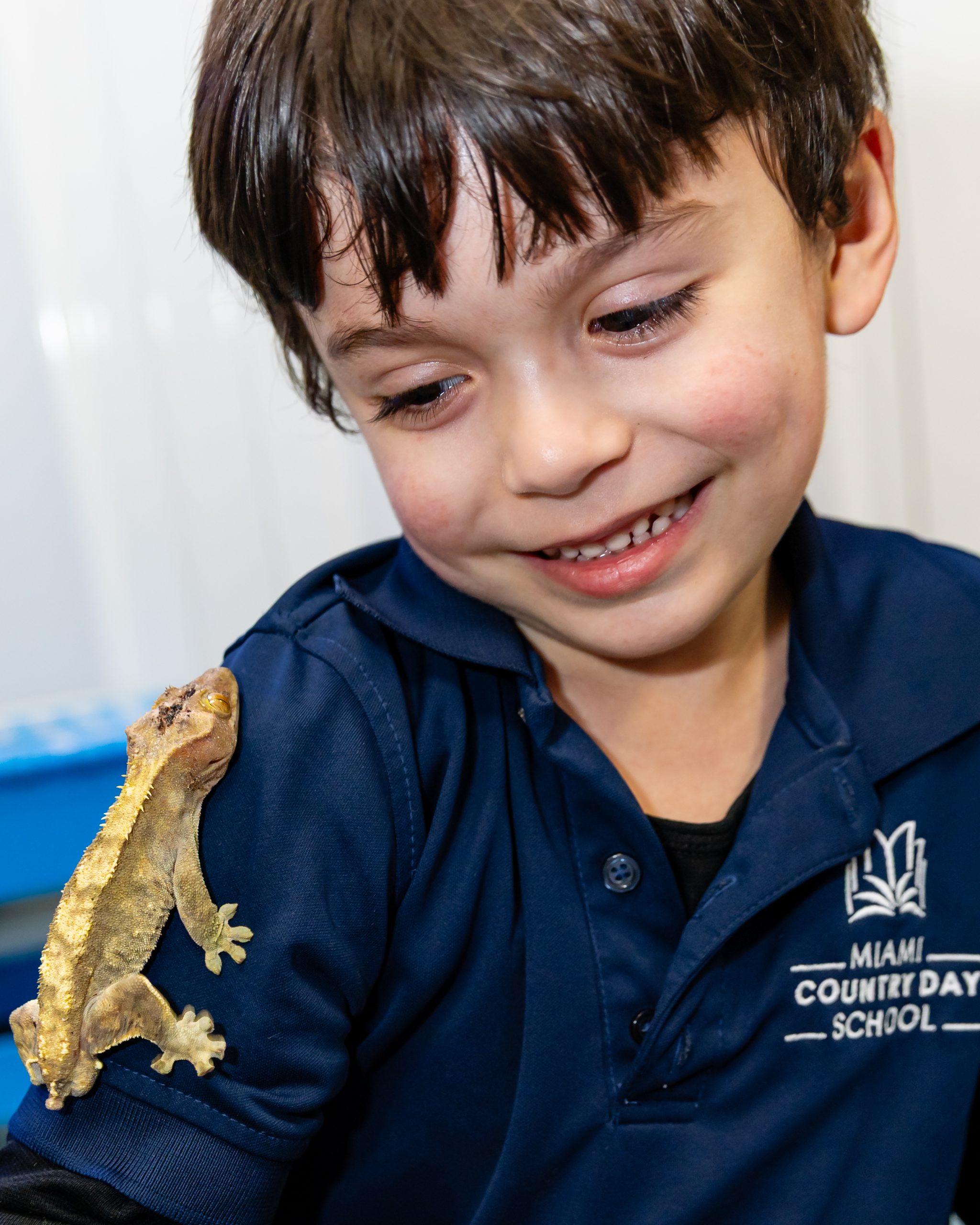 Early Childhood student smiling while holding a gecko