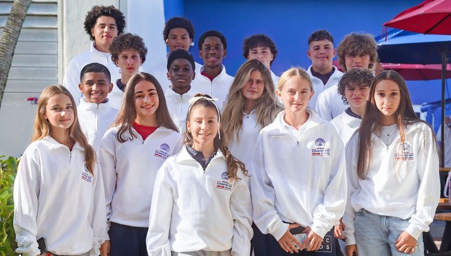 Group of Online School students posing together in white shirts