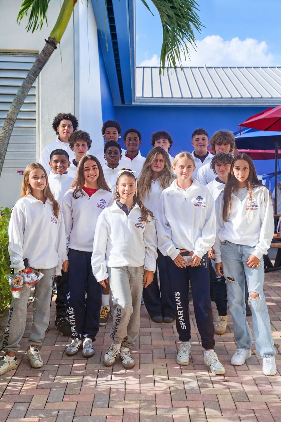 Online School students posing together outside a campus building