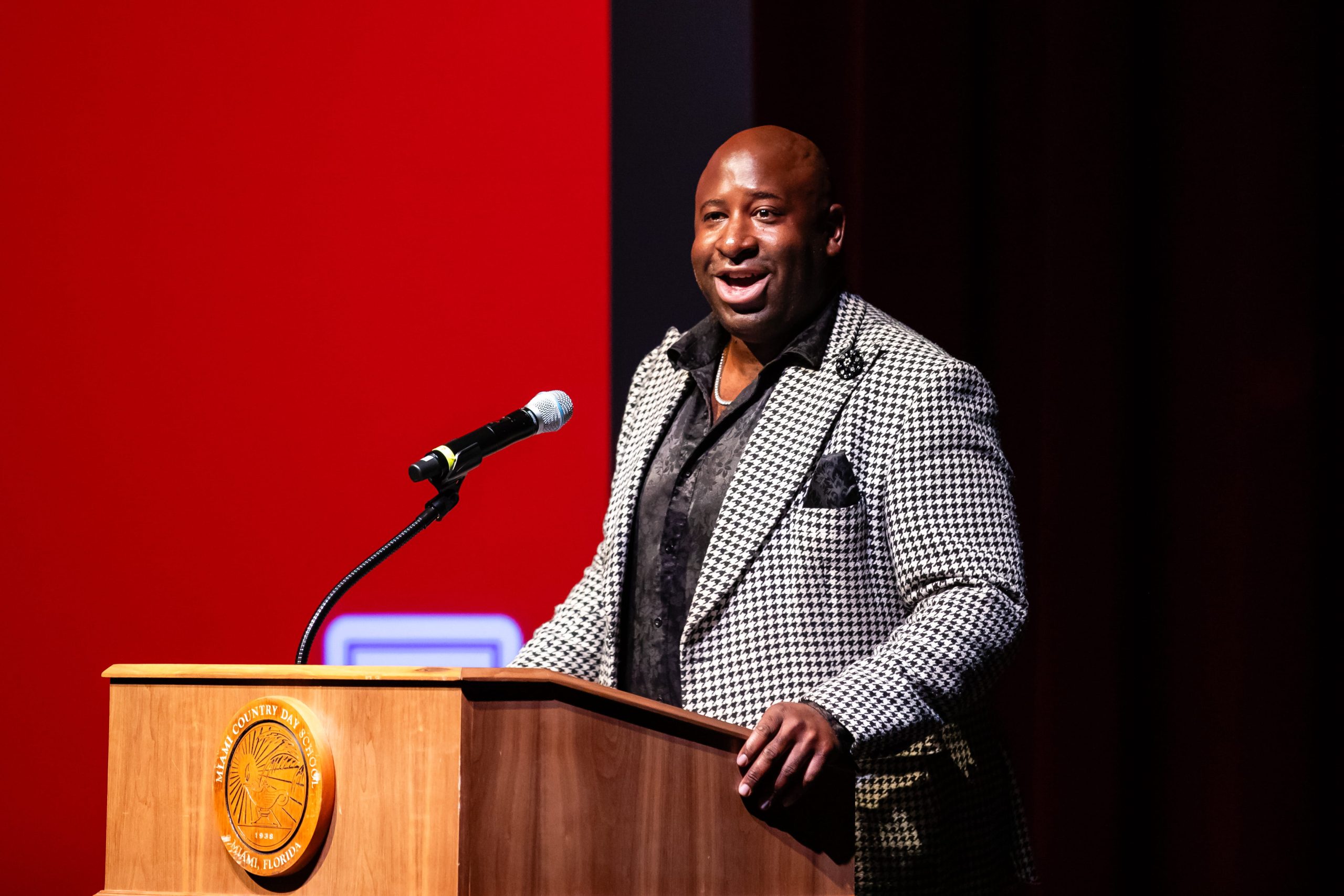 MCDS staff member speaking at a podium, shown on the Giving page