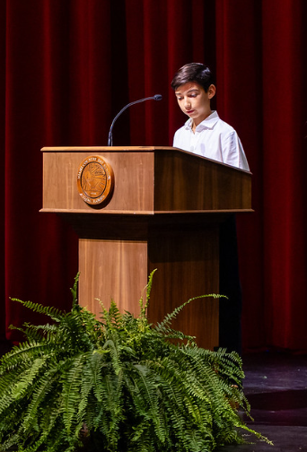 MCDS staff member speaking at a podium, shown on the Academics page