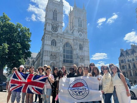 MCDS students on a GATEway trip, posing outside a cathedral with a flag banner